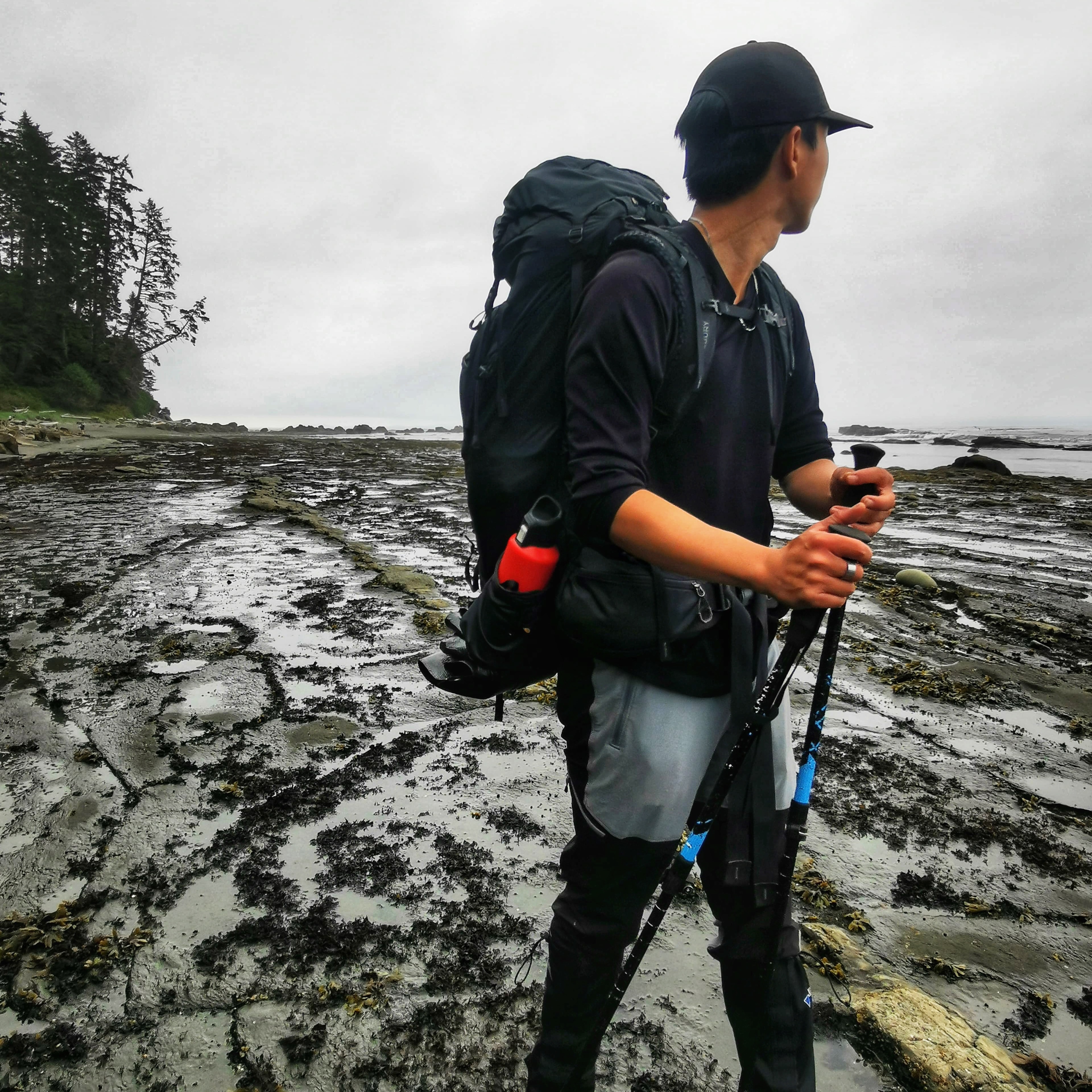 Will geared up on a rugged coastal trail with hiking poles and backpack.