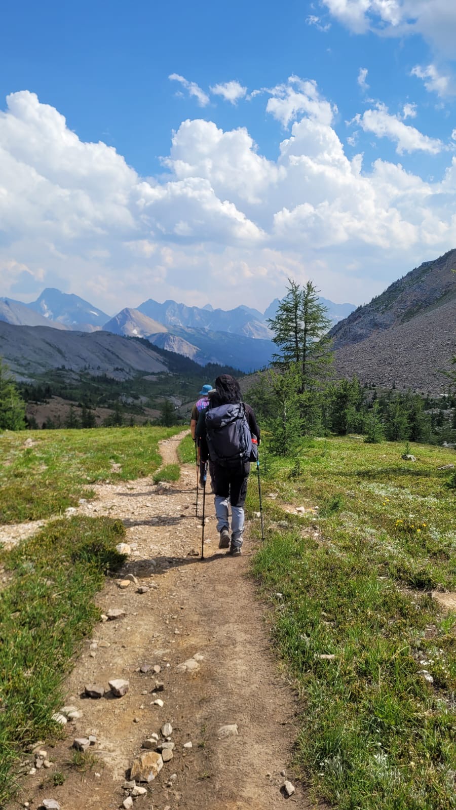 Will hiking along an alpine ridge with mountains in the distance.